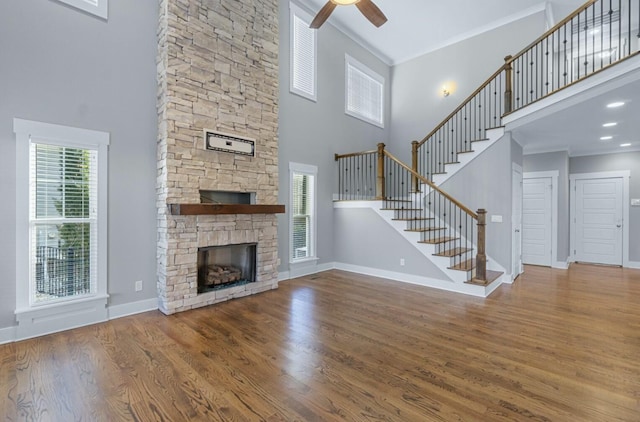 8520 Winter Refuge Way, Ooltewah, TN 37363 - unfurnished living room featuring a high ceiling, a ceiling fan, a stone fireplace, and wood finished floors