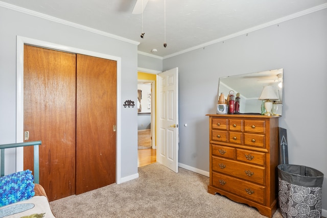 bedroom with a ceiling fan, baseboards, a closet, ornamental molding, and light carpet
