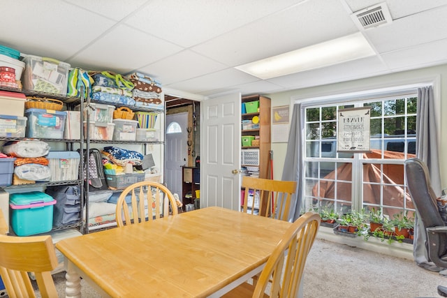 dining area with carpet floors, visible vents, and a drop ceiling
