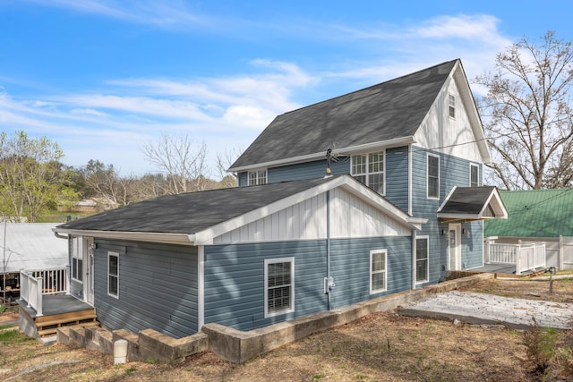 view of home's exterior with roof with shingles and a wooden deck