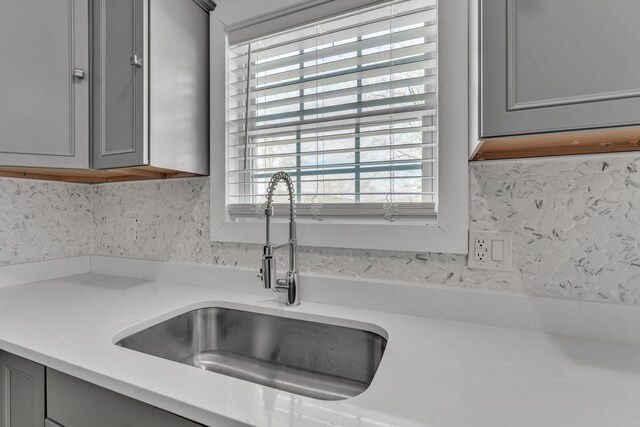 interior details with a sink, gray cabinetry, and light countertops