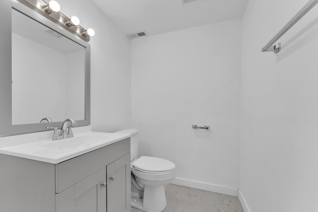 half bathroom with visible vents, vanity, marble finish floor, toilet, and baseboards