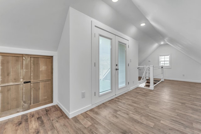 additional living space with wood finished floors, baseboards, recessed lighting, french doors, and vaulted ceiling