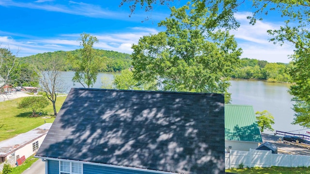 exterior space with a water view and fence