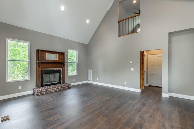 unfurnished living room featuring visible vents, baseboards, a fireplace, and high vaulted ceiling