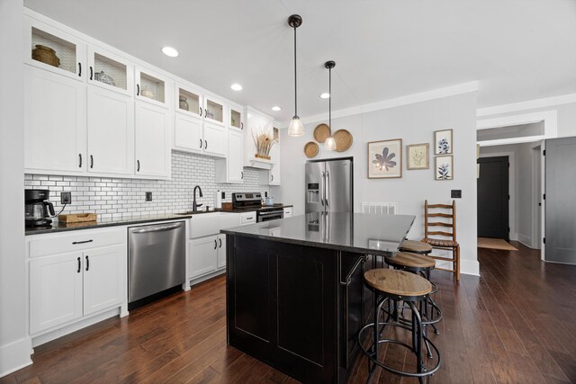 13111 Jones Gap Rd, Soddy Daisy, TN 37379 - kitchen featuring appliances with stainless steel finishes, dark countertops, decorative backsplash, a breakfast bar, and recessed lighting