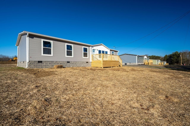 rear view of house with a deck and crawl space