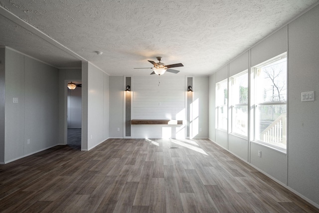 unfurnished living room with a ceiling fan, a textured ceiling, wood finished floors, and baseboards