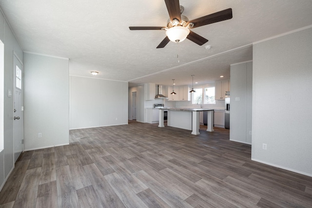 unfurnished living room with a textured ceiling, wood finished floors, a ceiling fan, and a sink