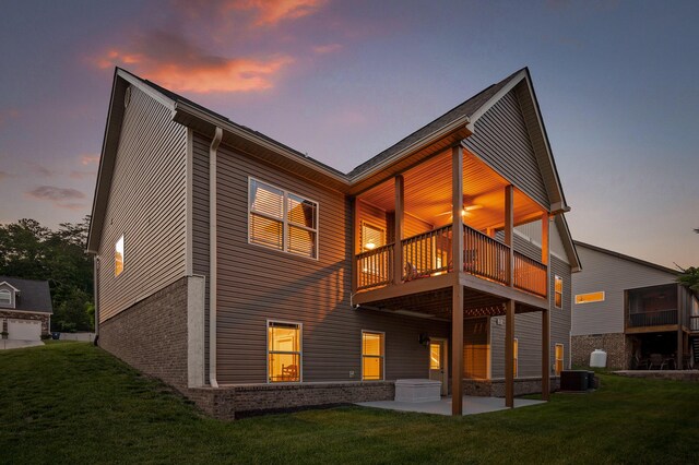 745 Soaring Eagle Cir, Hixson, TN 37343 - back of house at dusk featuring central air condition unit, a yard, a patio area, and a balcony