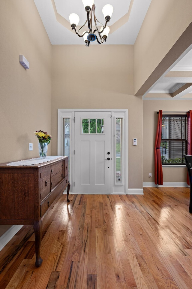 745 Soaring Eagle Cir, Hixson, TN 37343 - entryway featuring a towering ceiling, baseboards, a tray ceiling, light wood finished floors, and a notable chandelier