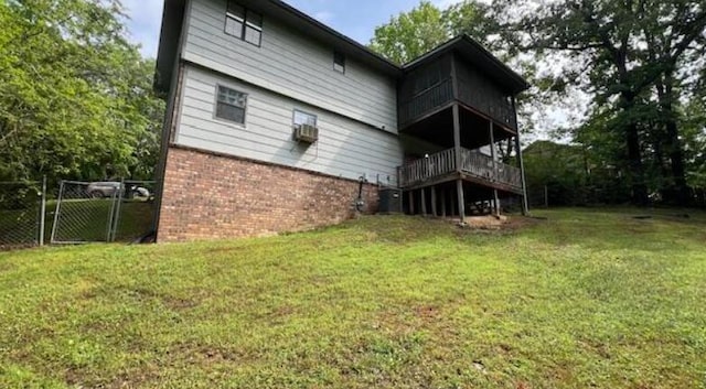 rear view of house with a lawn, a gate, and brick siding