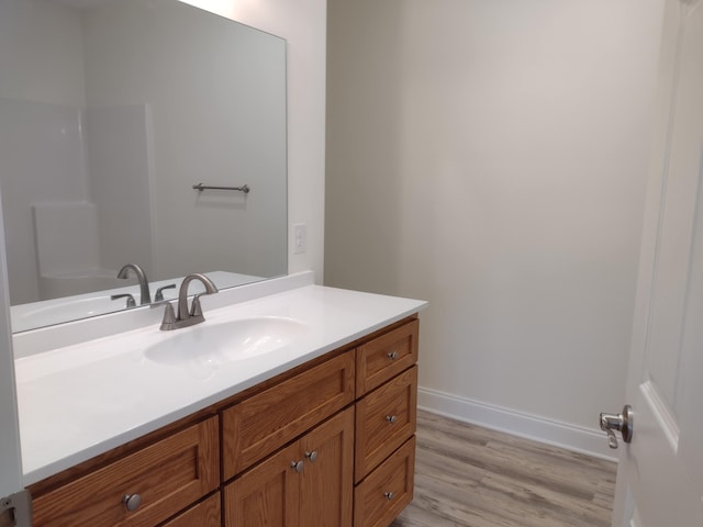 bathroom with vanity, baseboards, and wood finished floors