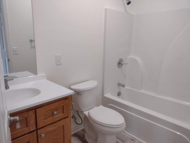 bathroom featuring toilet,  shower combination, wood finished floors, and vanity