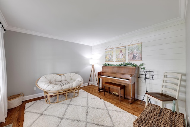 sitting room featuring ornamental molding, baseboards, and wood finished floors