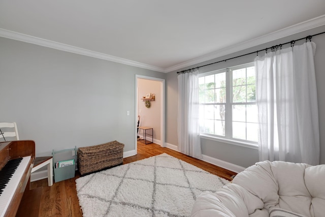 bedroom with crown molding, baseboards, and wood finished floors