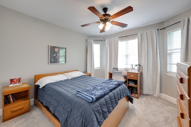 bedroom featuring baseboards, ceiling fan, and light colored carpet