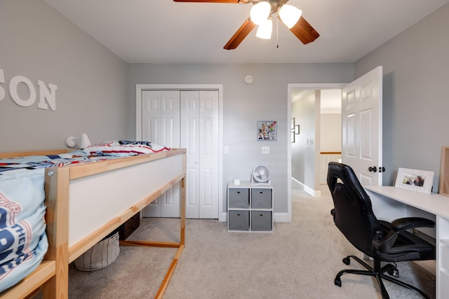 bedroom with light colored carpet, a closet, baseboards, and ceiling fan