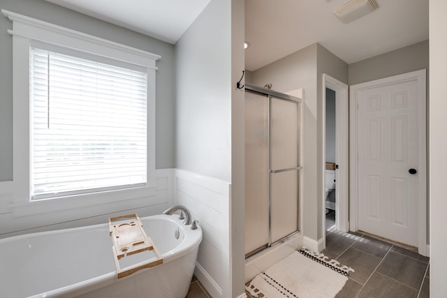 bathroom with a freestanding bath, wainscoting, visible vents, and a stall shower