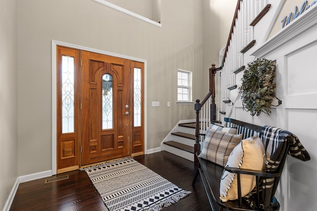 entryway with baseboards, stairway, visible vents, and hardwood / wood-style floors