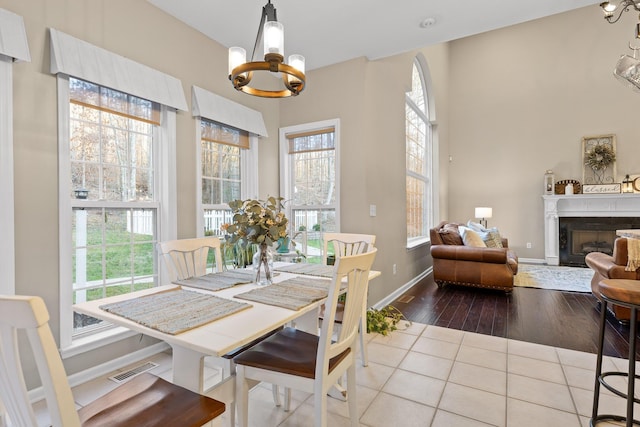 dining area featuring an inviting chandelier, a wealth of natural light, and a fireplace