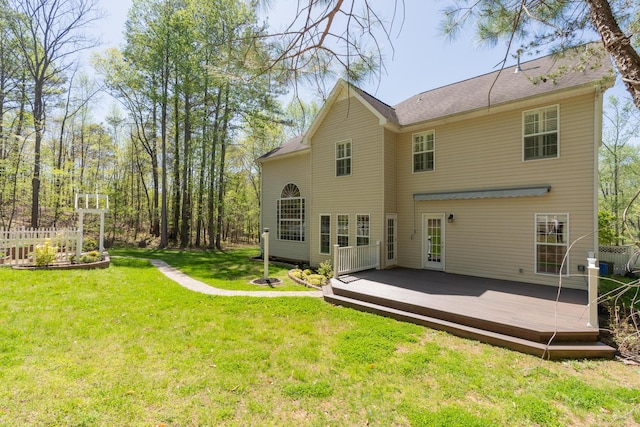 rear view of property featuring a lawn, fence, and a wooden deck