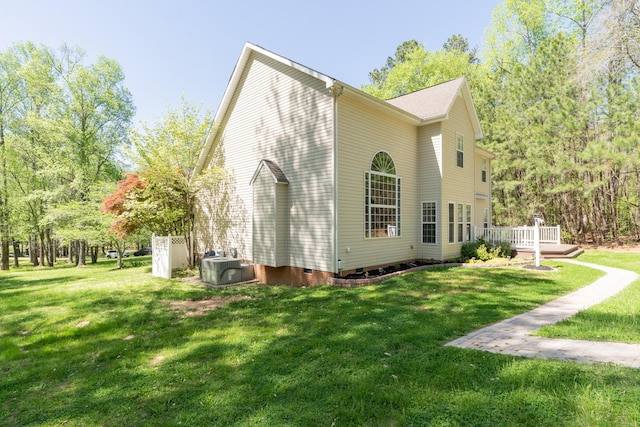 view of side of home with a deck, central AC unit, a yard, and crawl space