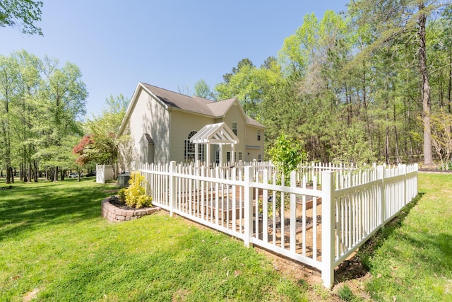 view of side of property with fence and a yard