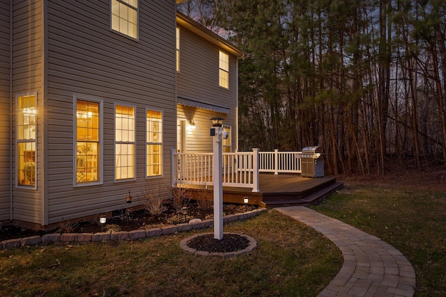 view of side of home with a deck and a yard