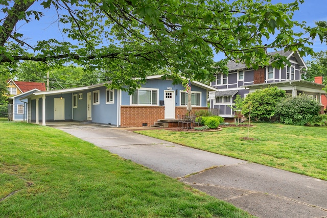 view of front of home with concrete driveway, a front lawn, an attached carport, and brick siding