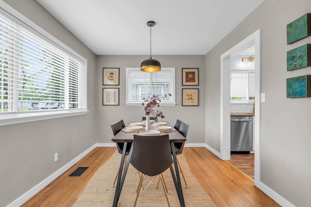 dining room featuring visible vents, light wood-type flooring, and plenty of natural light