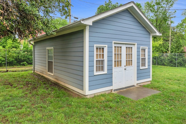 view of outdoor structure with fence and an outbuilding