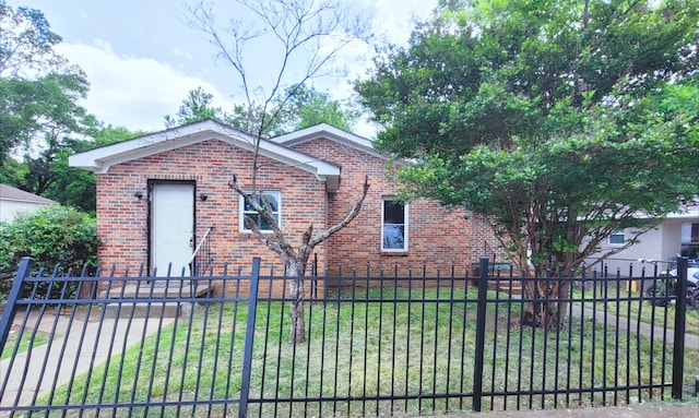 exterior space with a lawn, a fenced front yard, and brick siding