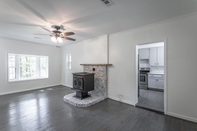 504 1st St, Lafayette, GA 30728 - unfurnished living room with crown molding, a wood stove, a ceiling fan, dark wood finished floors, and baseboards