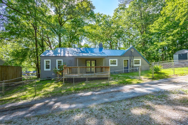 504 1st St, Lafayette, GA 30728 - view of front of house with a wooden deck, a chimney, metal roof, driveway, and stucco siding