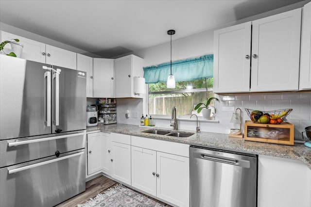 3818 Granada Dr, Chattanooga, TN 37411 - kitchen featuring appliances with stainless steel finishes, a sink, white cabinetry, light stone countertops, and backsplash