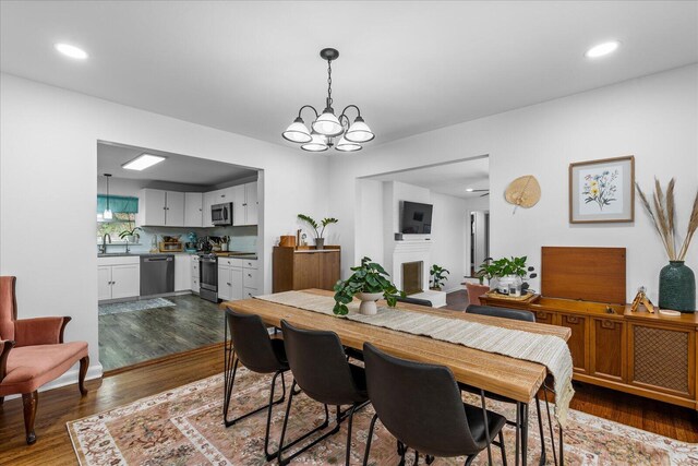 3818 Granada Dr, Chattanooga, TN 37411 - dining room with dark wood-style floors, a fireplace, a chandelier, and recessed lighting