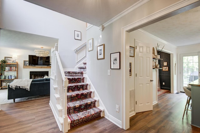 204 Stonecrest Cir, Ringgold, GA 30736 - stairway featuring wood finished floors, crown molding, a fireplace, baseboards, and a textured ceiling