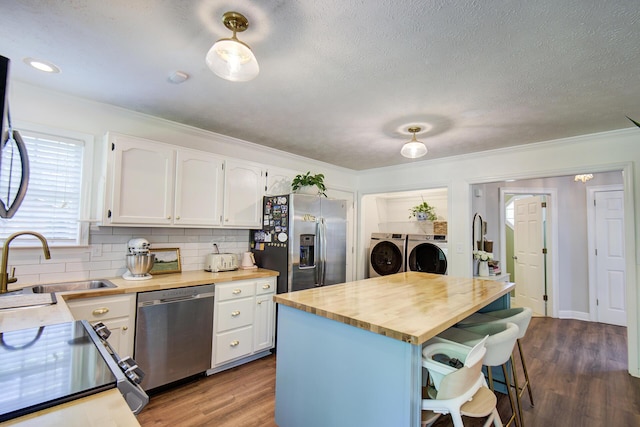 204 Stonecrest Cir, Ringgold, GA 30736 - kitchen with appliances with stainless steel finishes, butcher block countertops, separate washer and dryer, a sink, and white cabinetry