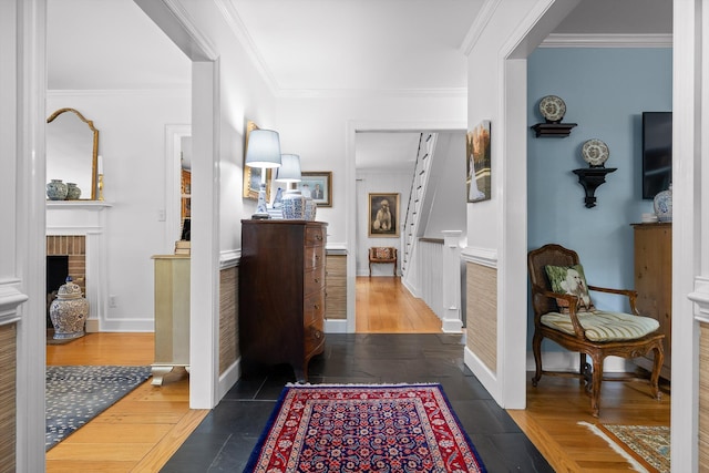 corridor with baseboards, ornamental molding, and wood finished floors