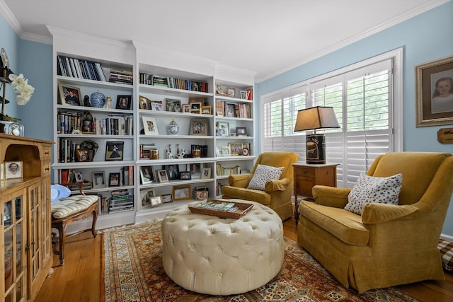 living area featuring crown molding, wood finished floors, and built in shelves
