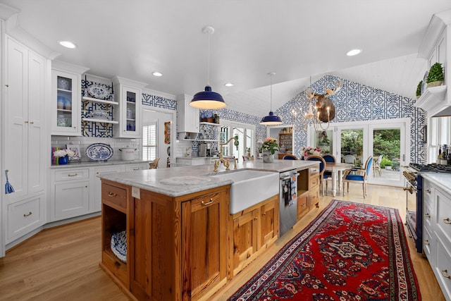 kitchen featuring a sink, light wood finished floors, lofted ceiling, and stainless steel appliances