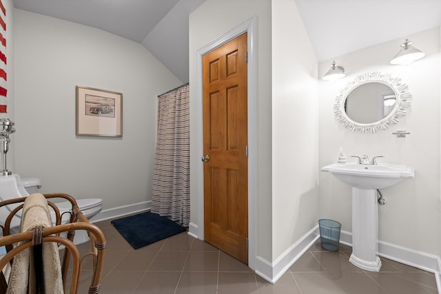 full bath with a sink, toilet, tile patterned floors, baseboards, and lofted ceiling