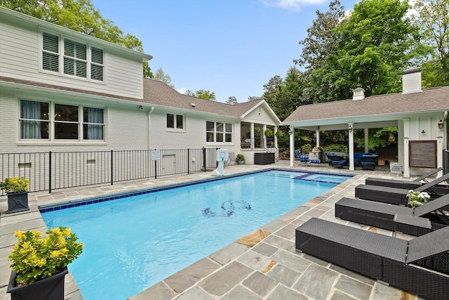 view of pool featuring an outdoor living space, a pool with connected hot tub, a patio area, a gazebo, and fence