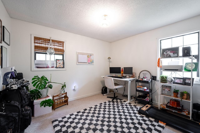 home office with a textured ceiling, baseboards, and carpet