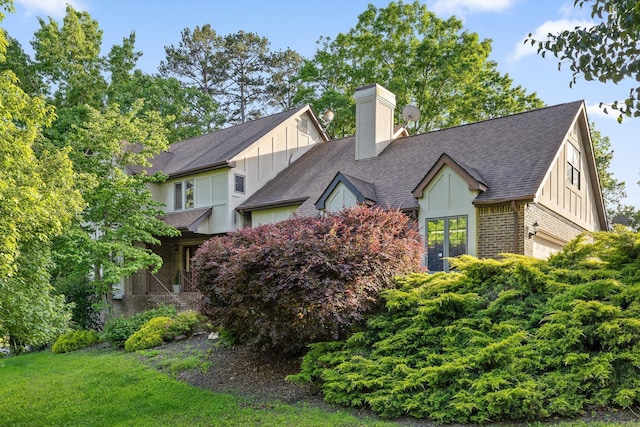9240 Shay Cv, Ooltewah, TN 37363 - view of front of property with board and batten siding, a chimney, a garage, brick siding, and roof with shingles