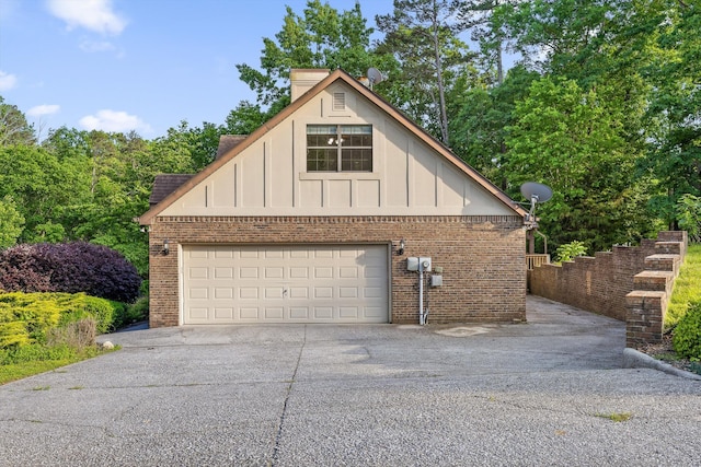 9240 Shay Cv, Ooltewah, TN 37363 - view of property exterior featuring board and batten siding, a garage, driveway, and brick siding