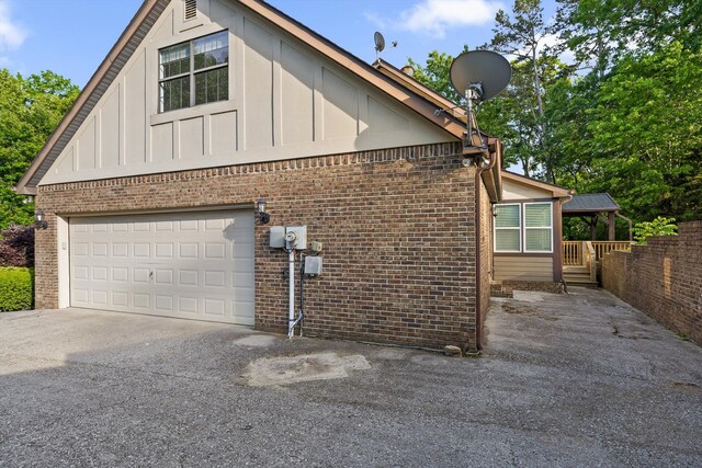 9240 Shay Cv, Ooltewah, TN 37363 - view of home's exterior featuring brick siding, a garage, concrete driveway, and board and batten siding