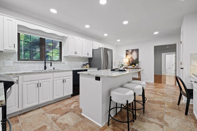 9240 Shay Cv, Ooltewah, TN 37363 - kitchen featuring freestanding refrigerator, a sink, black dishwasher, stone tile floors, and a center island