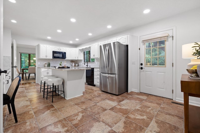 9240 Shay Cv, Ooltewah, TN 37363 - kitchen with black appliances, recessed lighting, a center island, white cabinetry, and stone tile floors